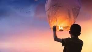 Picture of boy with paper lantern or balloon about to set flight